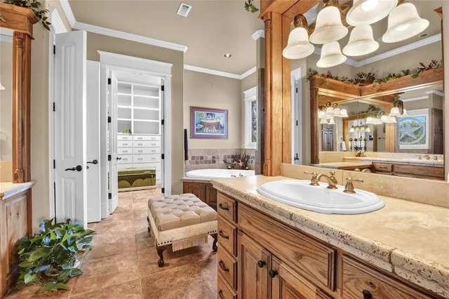 a spacious bathroom with a granite countertop sink a mirror and a bathtub