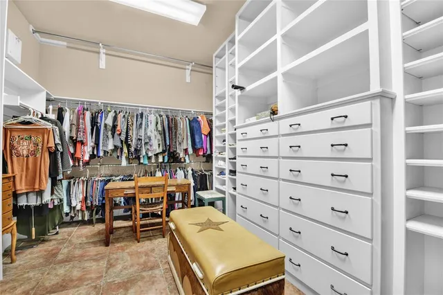 a view of walk in closet with clothes