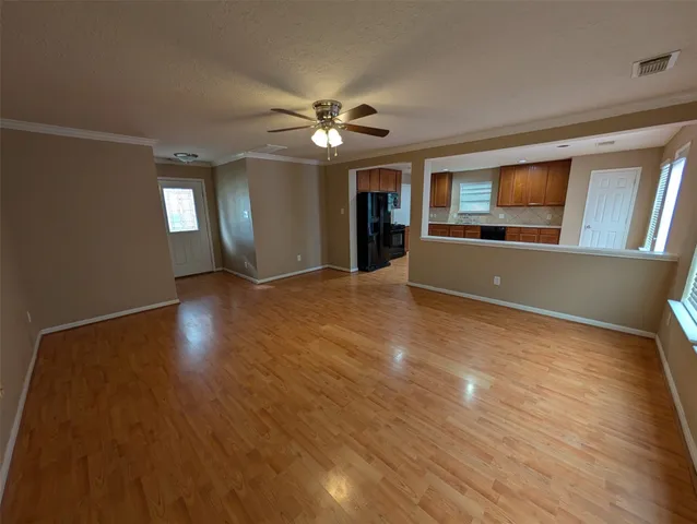 a view of an empty room with window and wooden floor