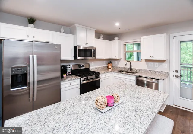 a kitchen with refrigerator a microwave and cabinets
