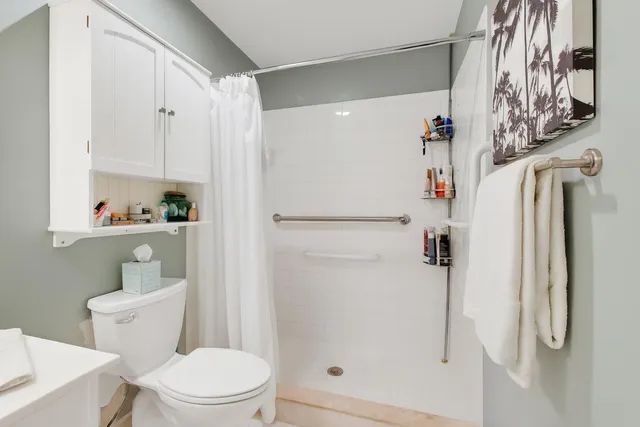 a white toilet sitting next to a bathroom sink and vanity