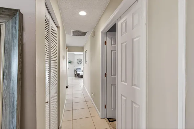 a view of a hallway with wooden floor and closet area