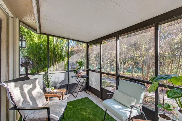 a living room with a floor to ceiling windows and a table