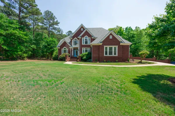 a front view of a house with yard and green space