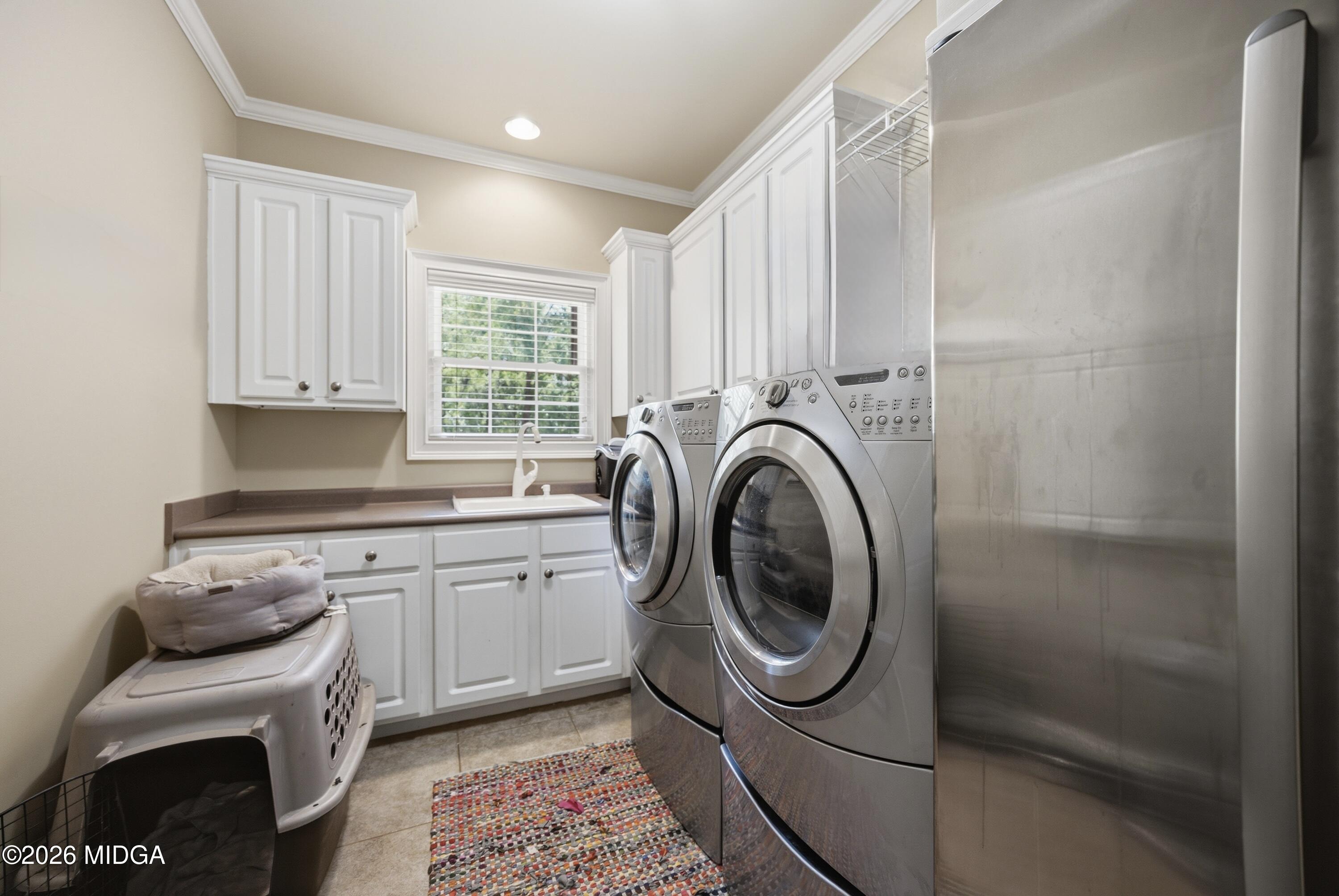 102 Tee Drive Forsyth, GA 31029 - Photo 11 of 53 a kitchen with a sink a washer and dryer next to a window