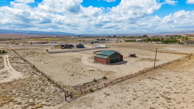 an empty room with windows and chandelier fan