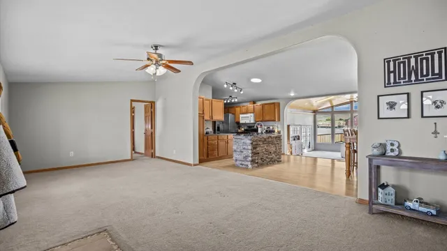 a view of a dining room and livingroom with furniture wooden floor a chandelier