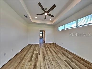 23414 Racine Avenue Port Charlotte, FL 33980 - Photo 3 of 12 a view of an empty room with wooden floor and a ceiling fan