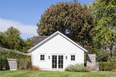 a view of a backyard with plants and large tree