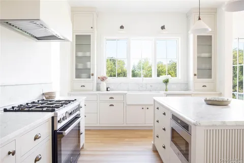 a kitchen with stainless steel appliances cabinets a large window and a sink