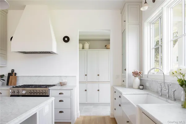 a kitchen with granite countertop a sink a stove and cabinets