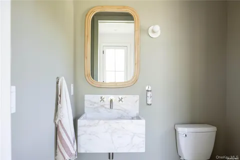 a bathroom with a toilet sink and mirror