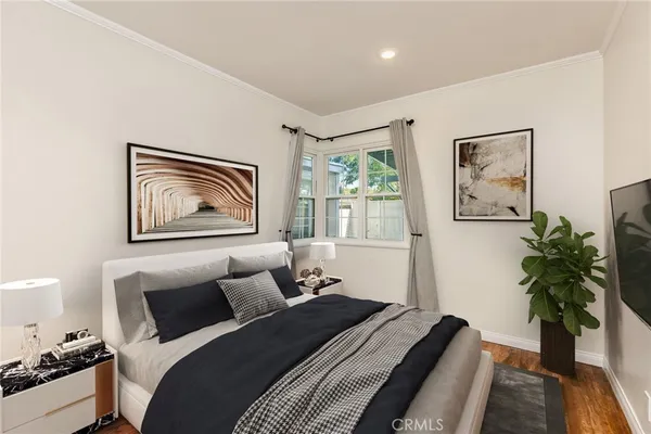 a bedroom with bed painting on the wall and a potted plant