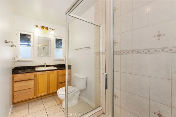 a bathroom with a granite countertop sink a mirror and a shower