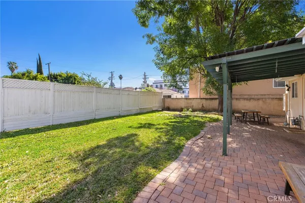 a view of a house with a backyard and a tree