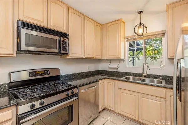 a kitchen with stainless steel appliances granite countertop a sink a stove and microwave