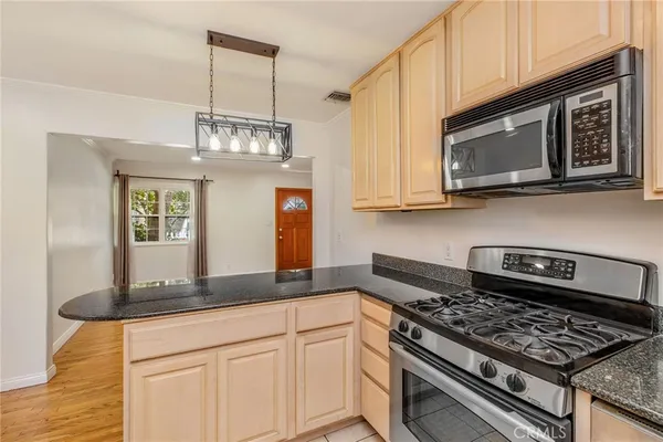 a kitchen with stainless steel appliances granite countertop a stove a microwave and cabinets