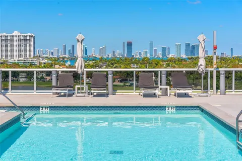 a swimming pool with outdoor seating and a garden