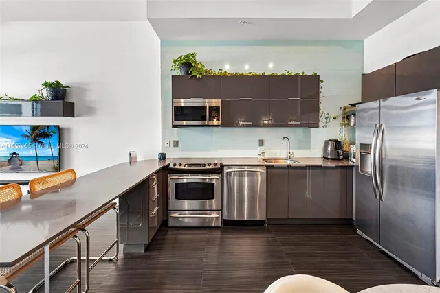 a kitchen with granite countertop a refrigerator and a stove top oven