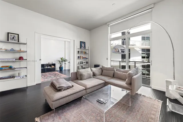 a living room with furniture wooden floor and a large window
