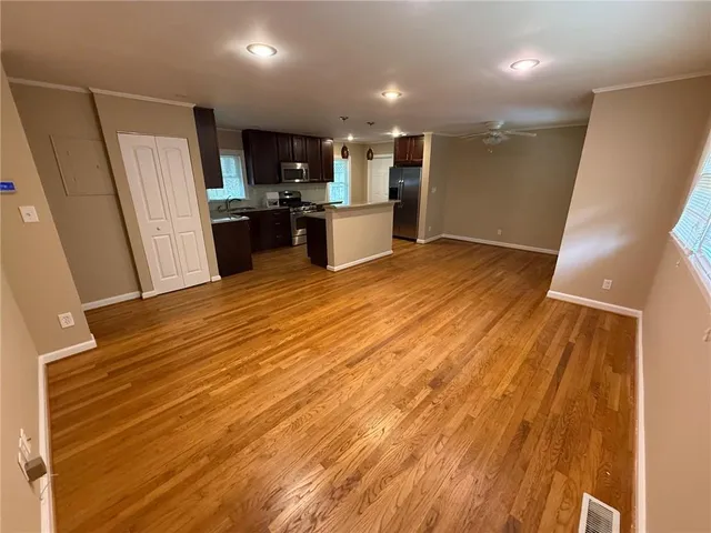 a view of kitchen with refrigerator stove and wooden floor