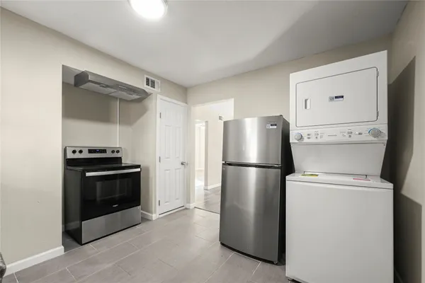 a white refrigerator freezer and a stove sitting inside of a kitchen
