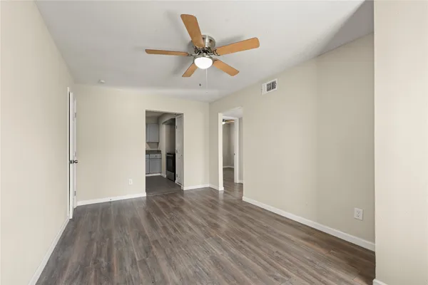 a view of an empty room with wooden floor