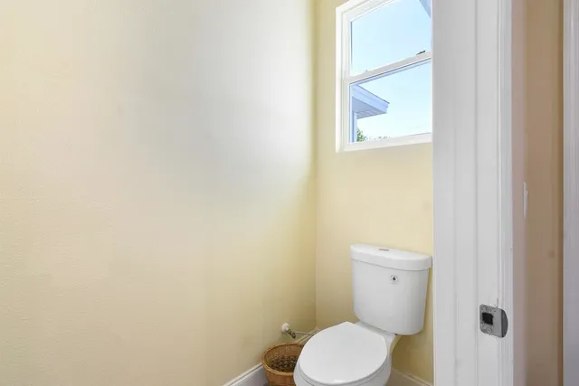 a white toilet sitting next to a white wall