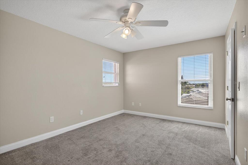 3339 Seaway Drive New Port Richey, FL 34652 - Photo 33 of 74 an empty room with a chandelier fan and windows
