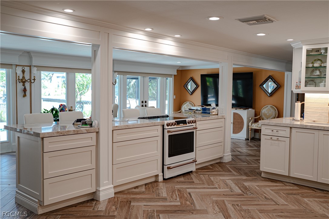 4902 Esplanade Street Estero, FL 34134 - Photo 11 of 40 a kitchen with white cabinets and appliances