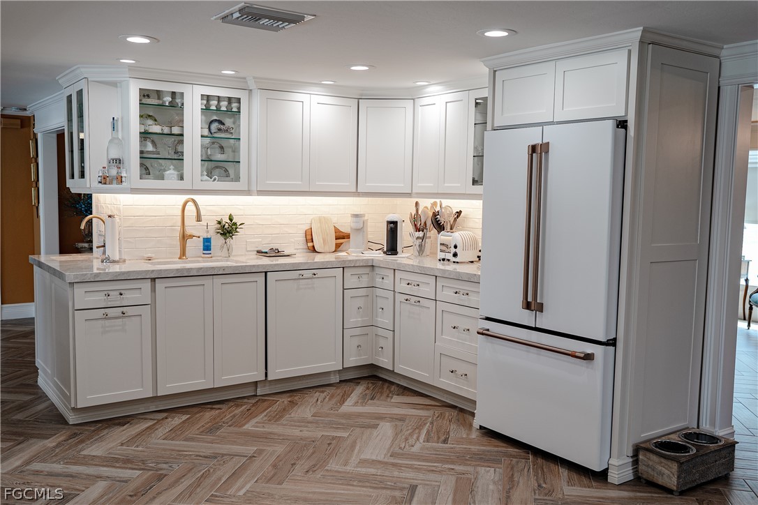 4902 Esplanade Street Estero, FL 34134 - Photo 12 of 40 a kitchen with white cabinets and refrigerator