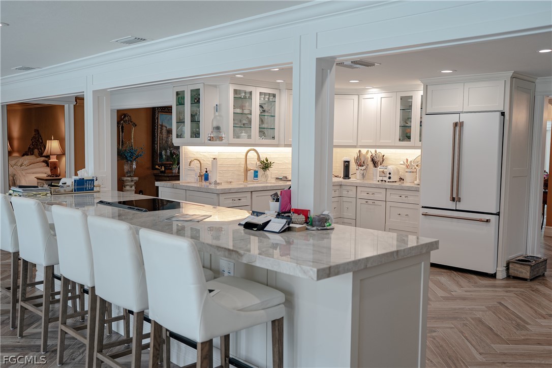 4902 Esplanade Street Estero, FL 34134 - Photo 13 of 40 a kitchen with stainless steel appliances granite countertop a table chairs stove and refrigerator