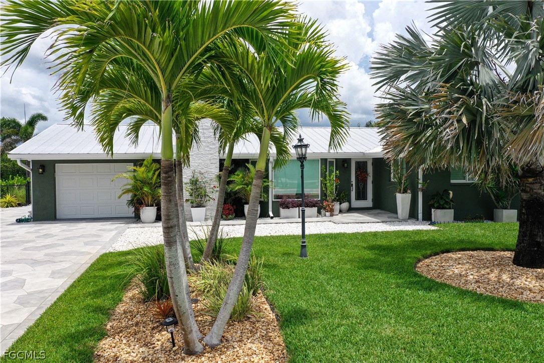 4902 Esplanade Street Estero, FL 34134 - Photo 2 of 40 a front view of a house with garden and porch