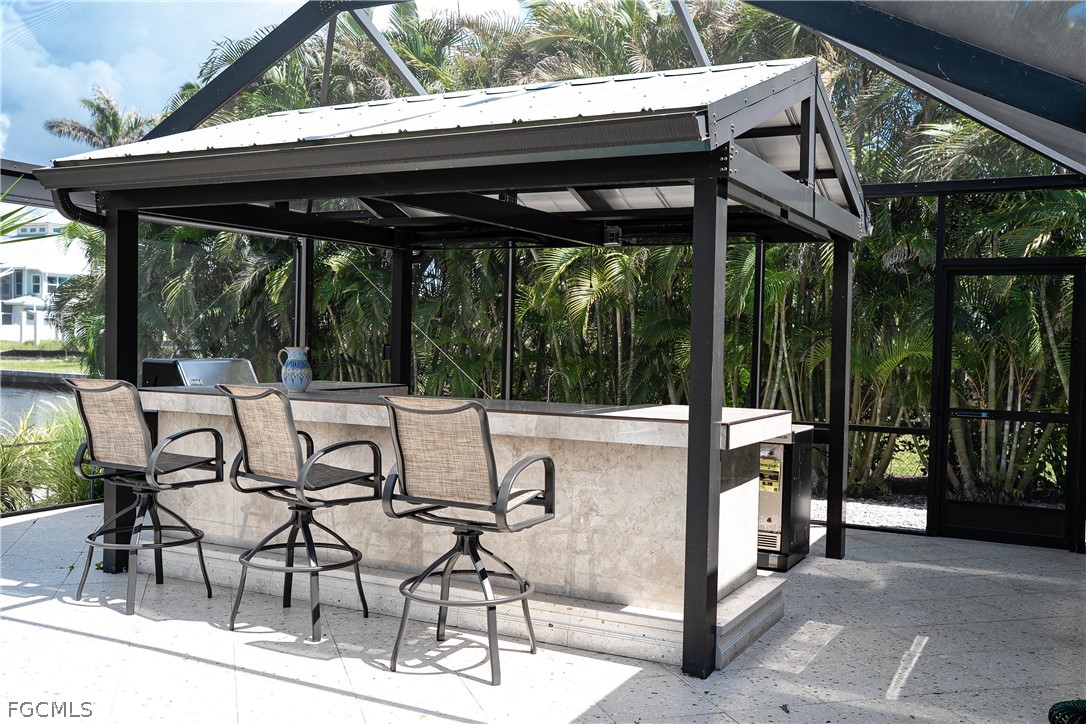 4902 Esplanade Street Estero, FL 34134 - Photo 23 of 40 a view of patio with chairs and table under an umbrella