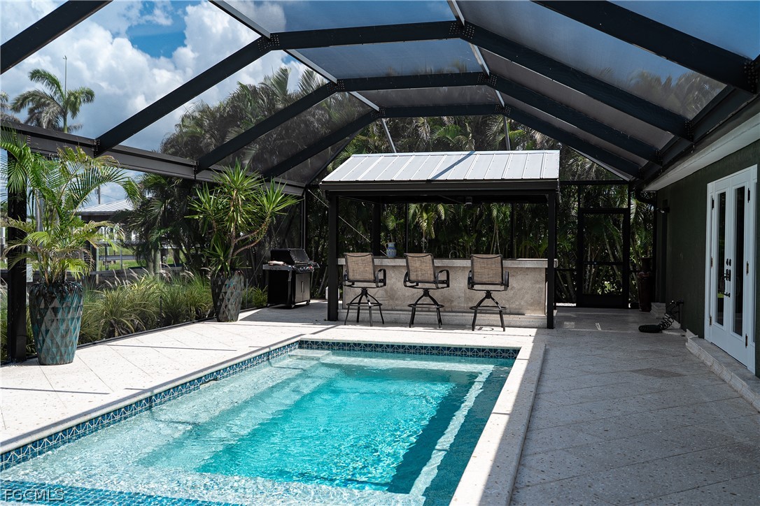4902 Esplanade Street Estero, FL 34134 - Photo 27 of 40 a view of a patio with a table chairs and a small yard