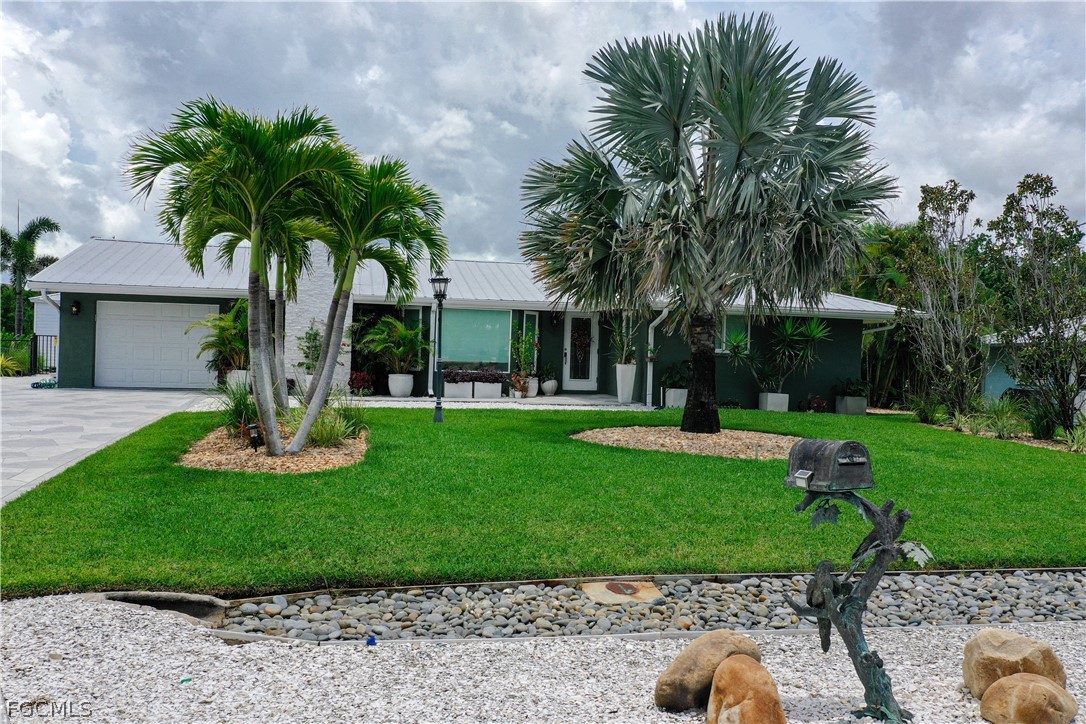 4902 Esplanade Street Estero, FL 34134 - Photo 3 of 40 a front view of a house with a yard and garage
