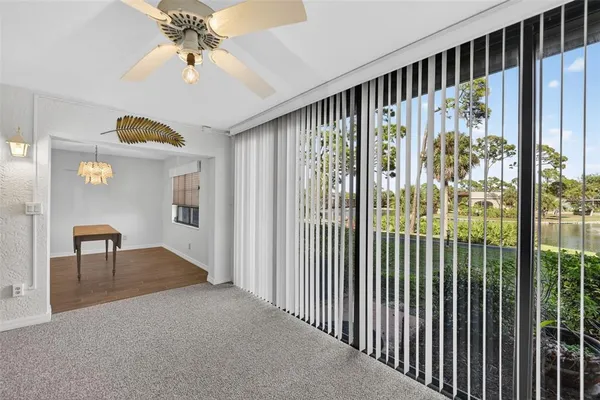 an empty room with a window and a fan