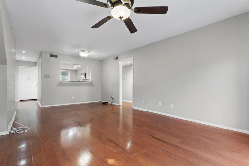4533 North O'Connor Road, Unit 2208 Irving, TX 75062 - Photo 4 of 28 a view of an empty room with wooden floor and a ceiling fan