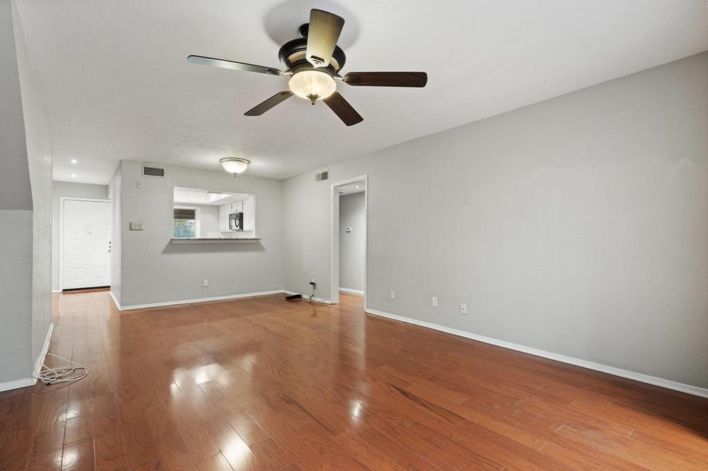 4533 North O'Connor Road, Unit 2208 Irving, TX 75062 - Photo 7 of 28 a view of an empty room with wooden floor and a ceiling fan