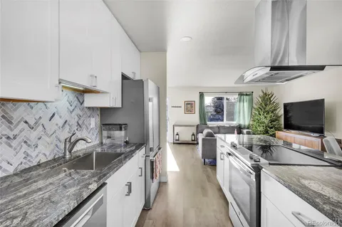 a kitchen with stainless steel appliances granite countertop a sink and a refrigerator