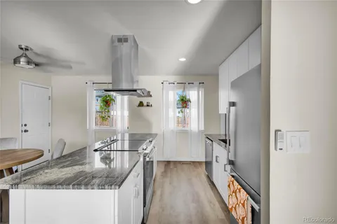 a kitchen with kitchen island granite countertop a sink cabinets and stainless steel appliances
