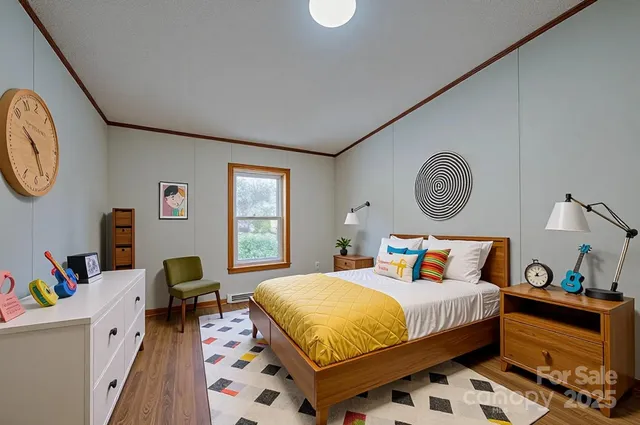 a bedroom with a bed a clock on wall and a window