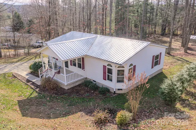 a aerial view of a house with a yard and large trees