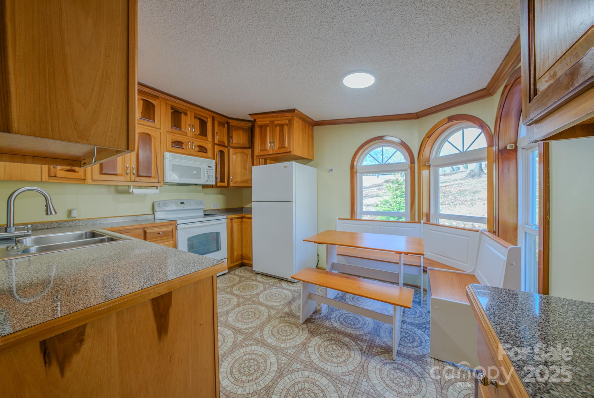 319 Sunrise Ridge Drive, Unit 19 Hendersonville, NC 28792 - Photo 5 of 30 a kitchen with a refrigerator a sink and cabinets