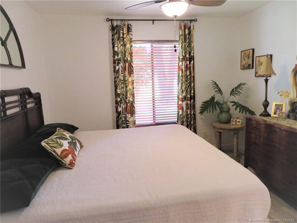 800 Northwest Fork Road, Unit 4 Stuart, FL 34994 - Photo 22 of 31 a bedroom with a bed and a chandelier