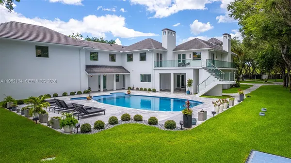 a view of a house with pool and chairs