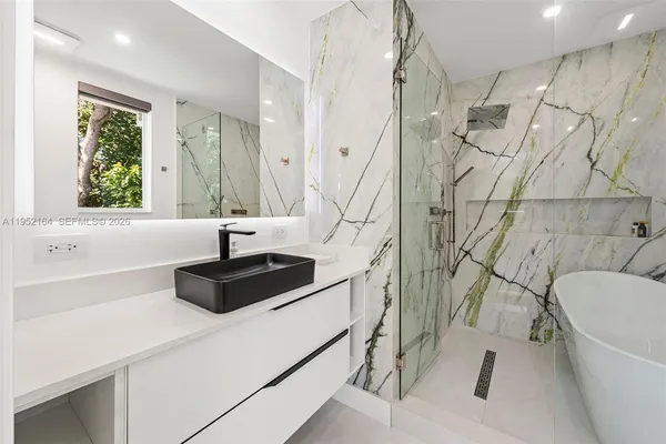 a bathroom with a sink a bathtub and a window