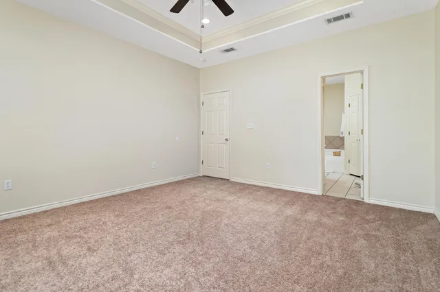 an empty room with chandelier fan