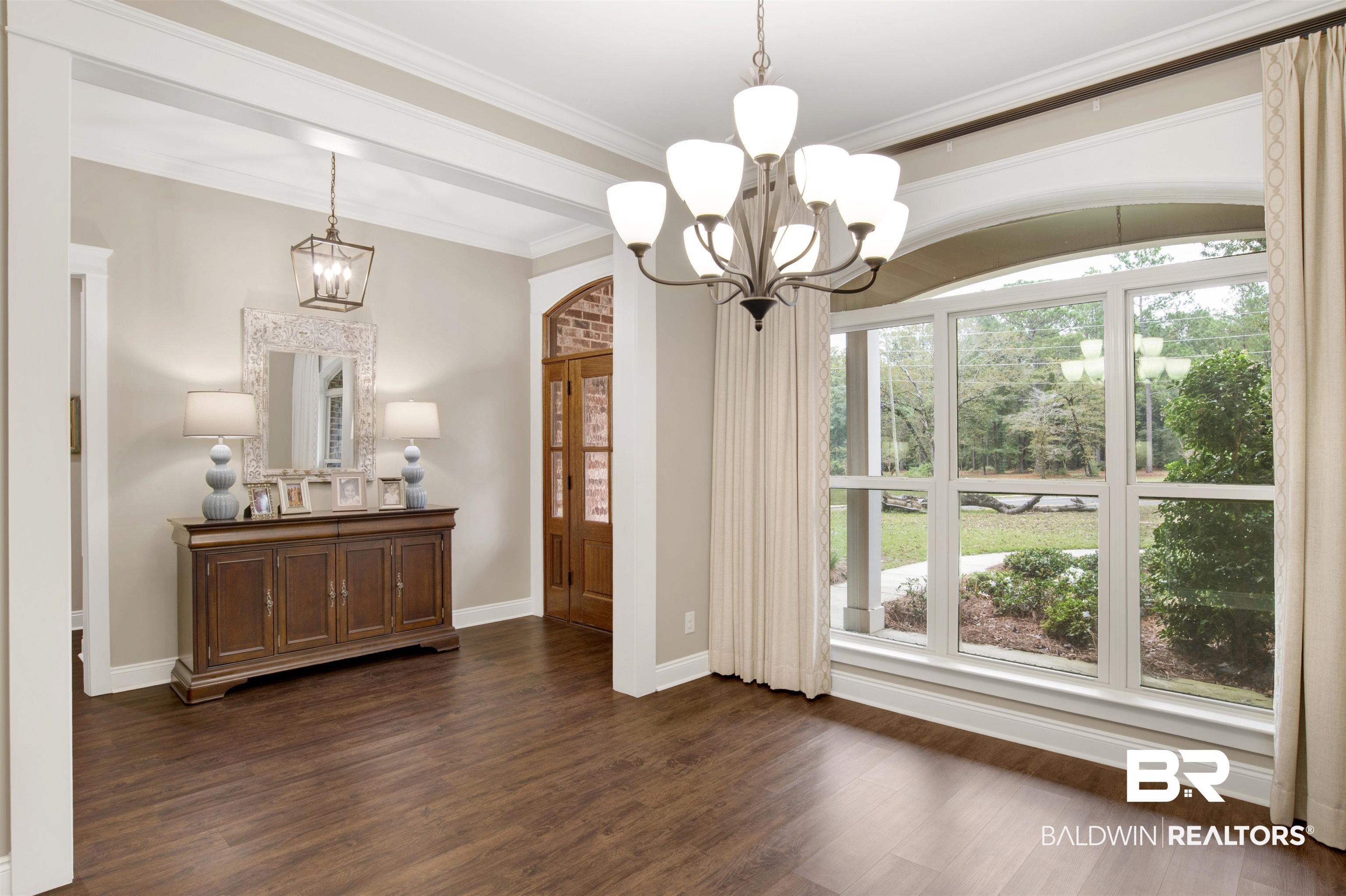 2440 Johnson Road West Mobile, AL 36695 - Photo 11 of 40 Dining area featuring ornamental molding, dark wood-type flooring, and an inviting chandelier