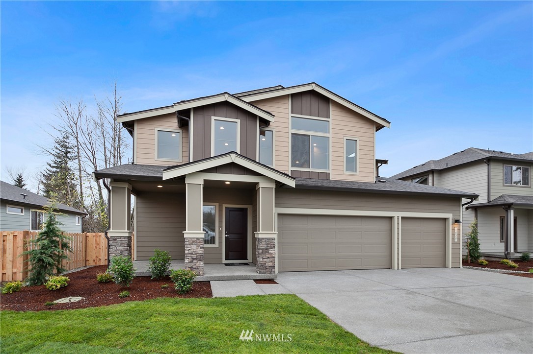 1630 Gault Street, Unit 6 Sumner, WA 98390 - Photo 1 of 24 a front view of a house with a yard and garage
